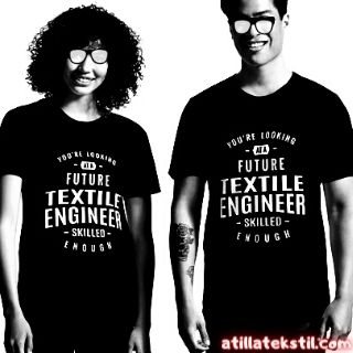 Erkek ve Kadın Siyah Üzerine Beyaz Baskı Yazılı Tişört Giymiş Ayakta Duruyorlar / Tişört baskısı İngilizce çevirisi şu anlama gelmektedir: "Yeterince becerili geleceğin tekstil mühendislerine bakıyorsun."