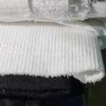 Beyaz renk kadife parça kumaş yakın çekim, kadife kumaşın yüzey dokusunu ve fitilli yapısını gösteren detaylı kumaş görünümü, beyaz kadife dokuma kumaş, giyim, dikiş, tekstil ve hobi projeleri için parça kumaş seçeneği.